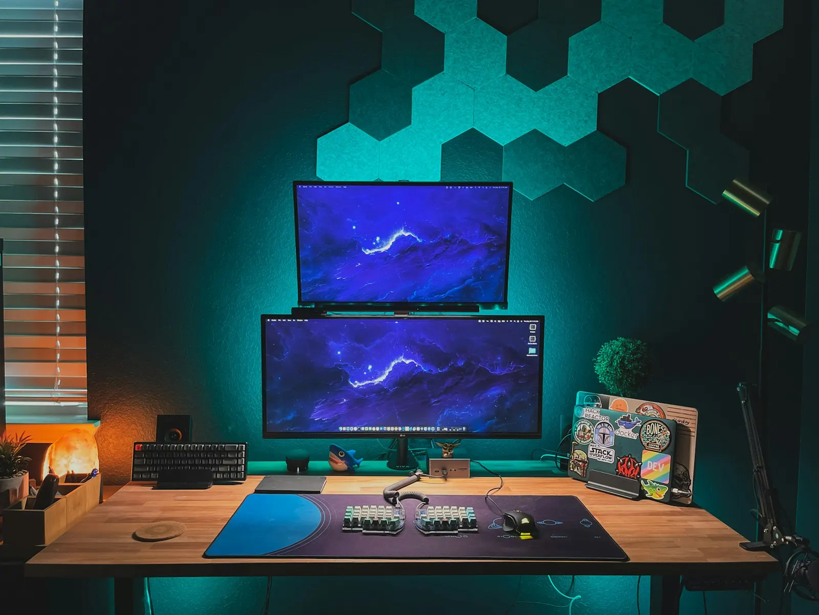 A clean developer desk with a monitor, mechanical keyboard, and a microphone on a boom arm